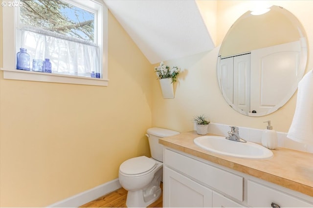 1537 NW 21st St, Lincoln City, OR 97367 - bathroom featuring vanity, toilet, lofted ceiling, wood finished floors, and baseboards