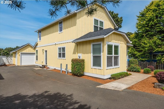1537 NW 21st St, Lincoln City, OR 97367 - view of front facade with asphalt driveway, an outbuilding, a garage, and board and batten siding