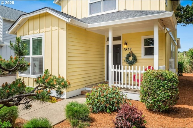 1537 NW 21st St, Lincoln City, OR 97367 - doorway to property featuring board and batten siding, a shingled roof, and a porch