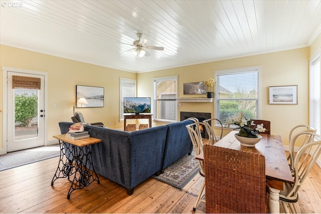 1537 NW 21st St, Lincoln City, OR 97367 - living area with light wood-type flooring, a ceiling fan, healthy amount of natural light, crown molding, and a warm lit fireplace