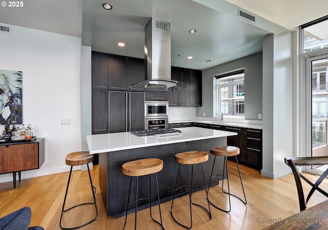 949 NW Overton St Unit 1302, Portland, OR 97209 - kitchen with built in appliances, island exhaust hood, a kitchen island, light wood-type flooring, and recessed lighting