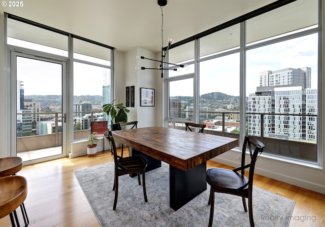 949 NW Overton St Unit 1302, Portland, OR 97209 - dining area with a view of city, healthy amount of natural light, a chandelier, light wood-type flooring, and floor to ceiling windows