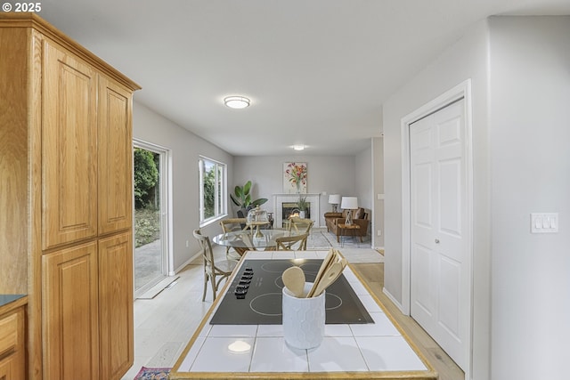 1974 SE 60th Ave, Hillsboro, OR 97123 - dining space with a glass covered fireplace, light wood finished floors, and baseboards