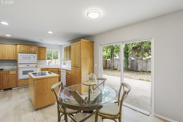 1974 SE 60th Ave, Hillsboro, OR 97123 - kitchen featuring white appliances, a kitchen island, light wood-style flooring, recessed lighting, and a sink