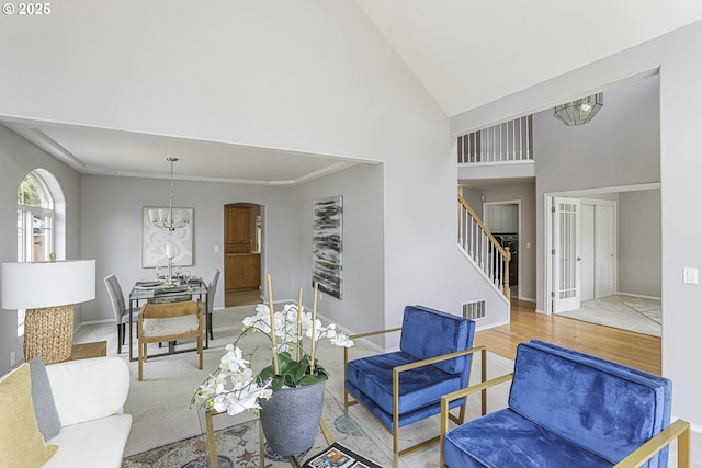 1974 SE 60th Ave, Hillsboro, OR 97123 - living area featuring stairs, a chandelier, high vaulted ceiling, arched walkways, and wood finished floors