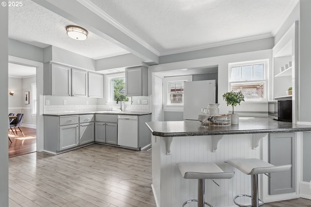 1902 N Terry St, Portland, OR 97217 - kitchen featuring white appliances, gray cabinetry, a kitchen bar, a textured ceiling, and ornamental molding