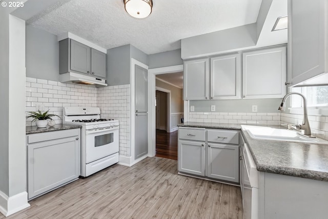 1902 N Terry St, Portland, OR 97217 - kitchen with white gas range oven, a sink, under cabinet range hood, light wood-type flooring, and gray cabinetry