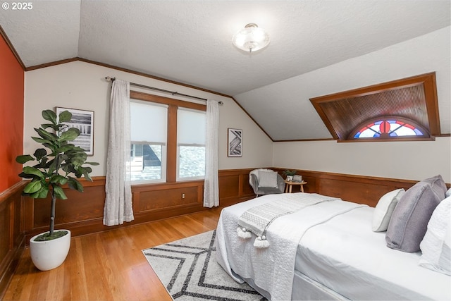 1902 N Terry St, Portland, OR 97217 - bedroom featuring lofted ceiling, a textured ceiling, wood finished floors, wainscoting, and crown molding