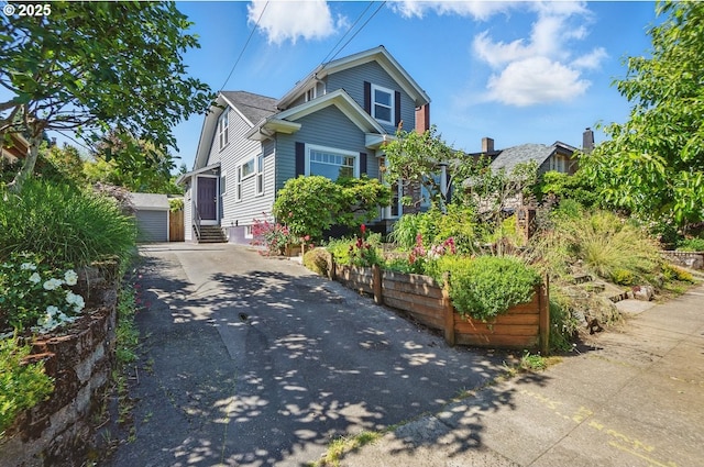 1902 N Terry St, Portland, OR 97217 - view of front of house with entry steps, a detached garage, and an outdoor structure