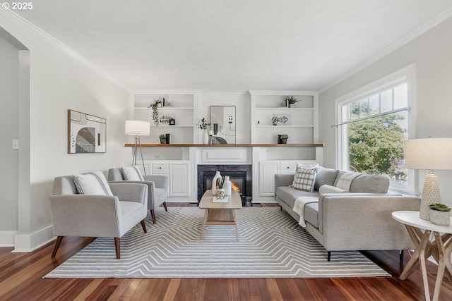1902 N Terry St, Portland, OR 97217 - living room featuring wood finished floors, crown molding, arched walkways, a fireplace, and baseboards