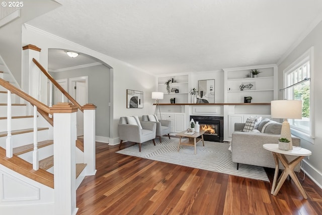 1902 N Terry St, Portland, OR 97217 - living room featuring dark wood finished floors, crown molding, baseboards, a glass covered fireplace, and stairs