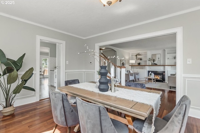 1902 N Terry St, Portland, OR 97217 - dining area with wood finished floors, crown molding, wainscoting, a warm lit fireplace, and built in features