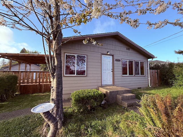 bungalow-style house with fence, a front lawn, and crawl space