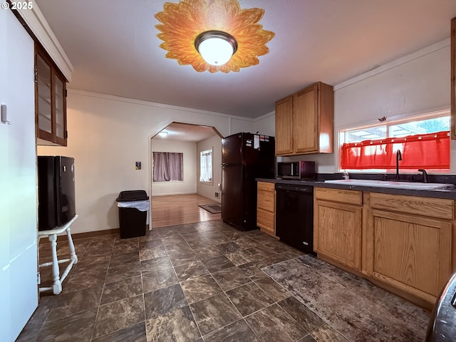 kitchen featuring a sink, black appliances, arched walkways, stone finish flooring, and dark countertops