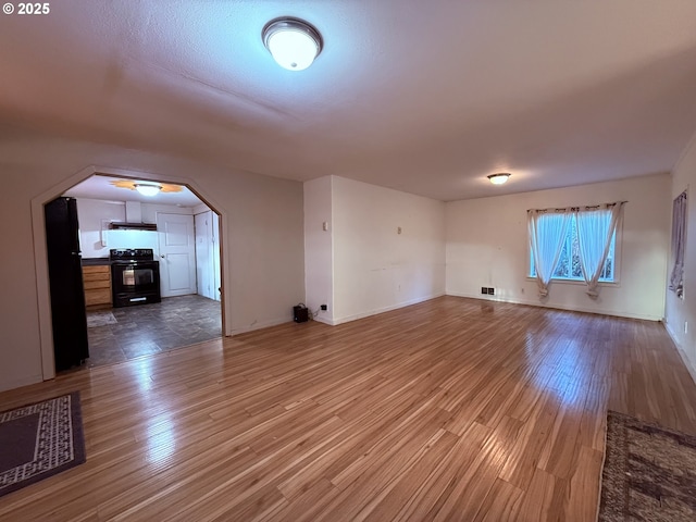 bonus room featuring arched walkways, baseboards, visible vents, and wood finished floors