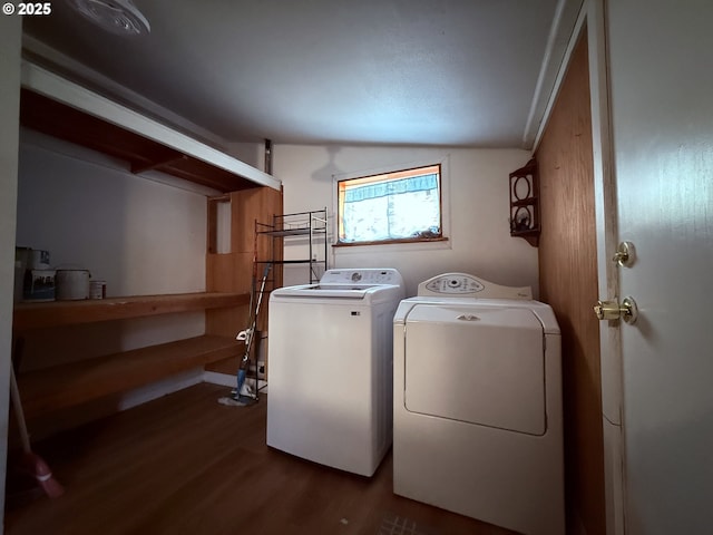 laundry room with laundry area, dark wood-style floors, and washer and dryer