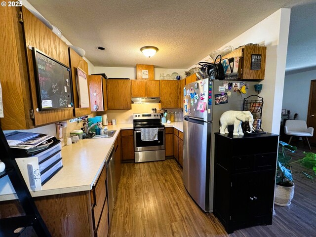 1221 Lewis St, The Dalles, OR 97058 - kitchen with appliances with stainless steel finishes, brown cabinets, light countertops, wood finished floors, and a textured ceiling