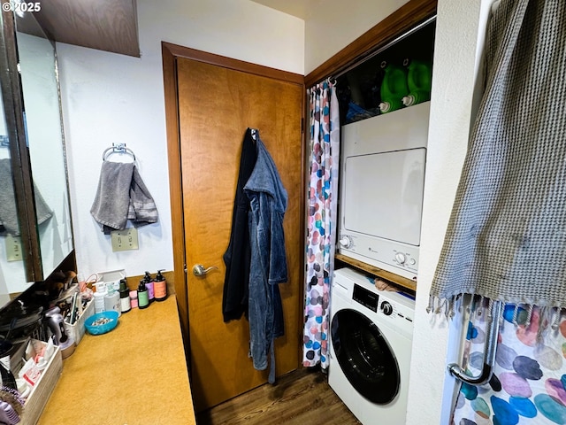 laundry room with stacked washer and dryer, laundry area, and dark wood finished floors