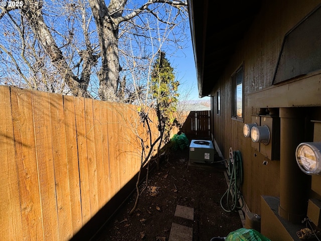 view of yard with fence and central AC