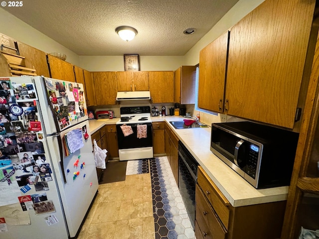 kitchen featuring light countertops, white appliances, a sink, and under cabinet range hood