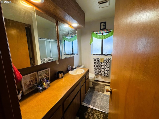 bathroom featuring visible vents, vanity, and toilet