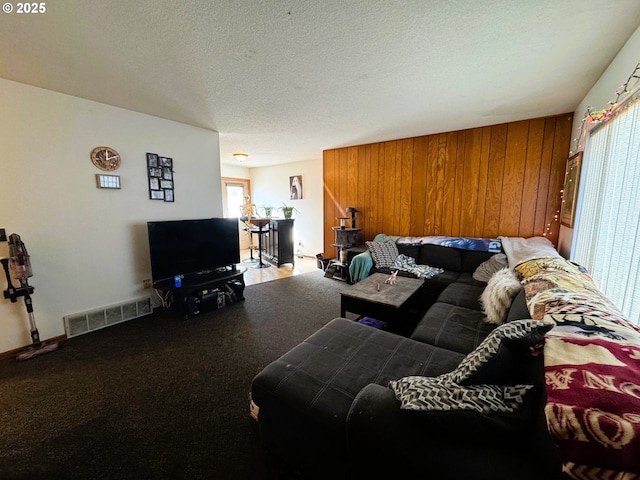 living room with a wealth of natural light, visible vents, and a textured ceiling