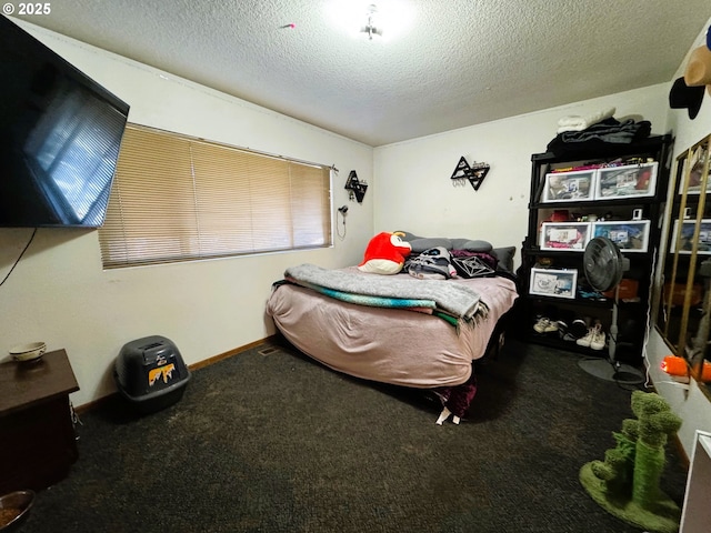 bedroom featuring a textured ceiling, carpet, and baseboards