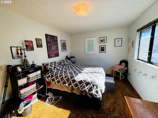 bedroom with dark carpet and a textured ceiling