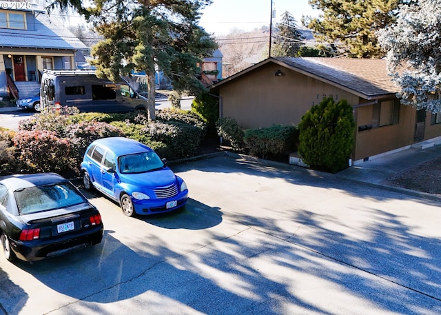 view of side of home with roof with shingles and stucco siding