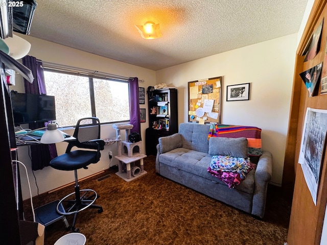 office space with a textured ceiling, dark colored carpet, and visible vents