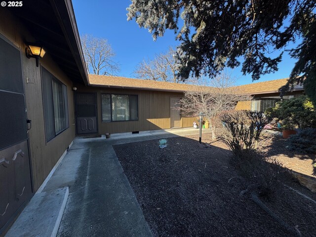 1221 Lewis St, The Dalles, OR 97058 - view of exterior entry with a shingled roof and a patio