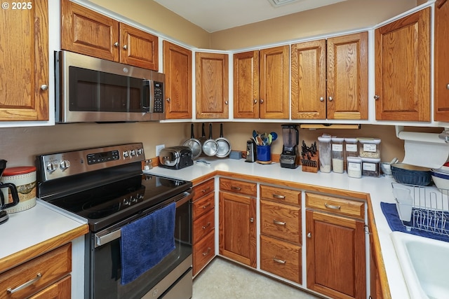 28805 Royal Ave, Eugene, OR 97402 - kitchen with stainless steel appliances, brown cabinetry, and light countertops