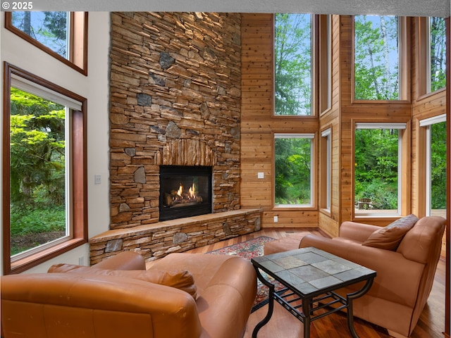 24982 E Tillicum St, Welches, OR 97067 - living area featuring a towering ceiling, a fireplace, wooden walls, and wood finished floors