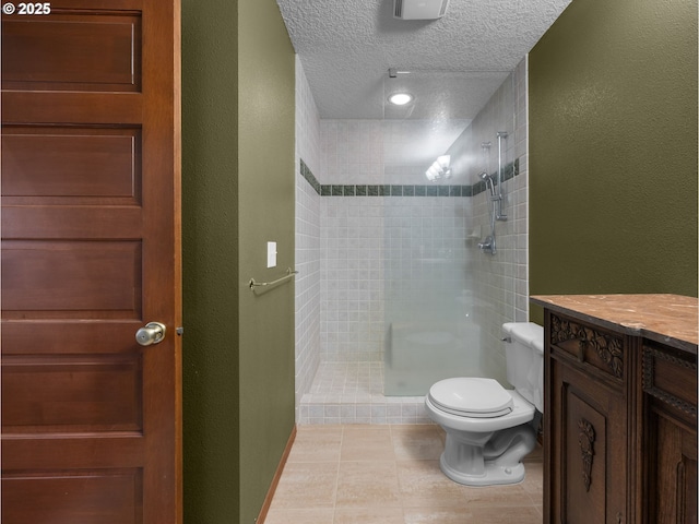 24982 E Tillicum St, Welches, OR 97067 - bathroom with toilet, tiled shower, tile patterned flooring, a textured ceiling, and vanity