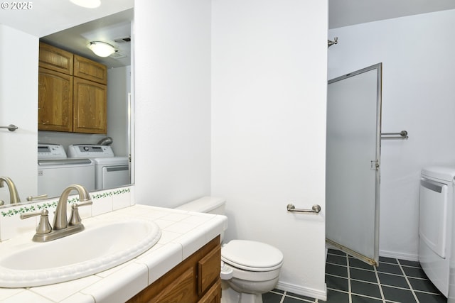 bathroom with separate washer and dryer, toilet, vanity, and tile patterned flooring