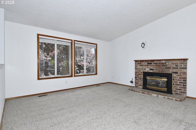 unfurnished living room with carpet floors, a textured ceiling, baseboards, and a fireplace