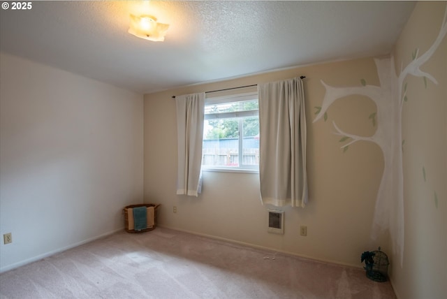 spare room with a textured ceiling and light colored carpet