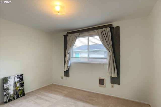 unfurnished room with light carpet and baseboards