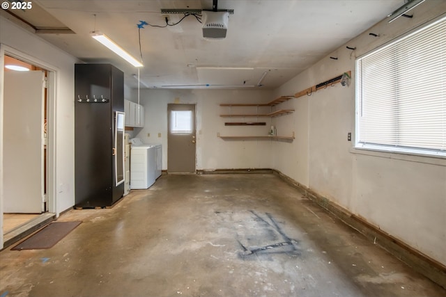 garage with baseboards, washer and dryer, and a garage door opener