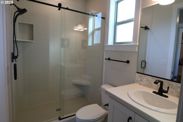 full bath with a stall shower, vanity, toilet, and backsplash