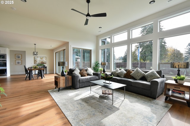 living room featuring wood-type flooring, plenty of natural light, and ceiling fan