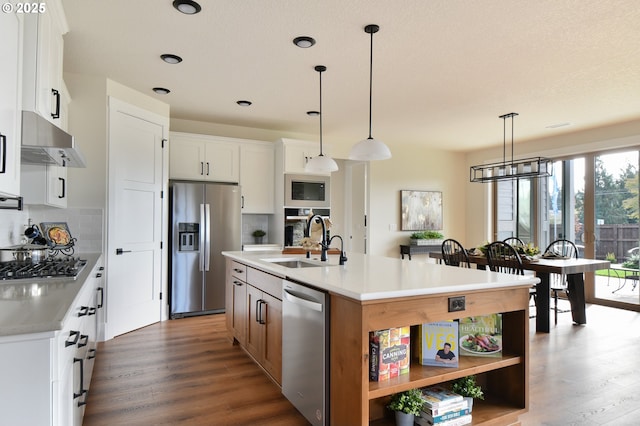 kitchen featuring a center island with sink, black appliances, backsplash, and white cabinets