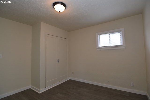 3159 Florida St, Longview, WA 98632 - unfurnished bedroom with dark wood finished floors, a closet, and a textured ceiling