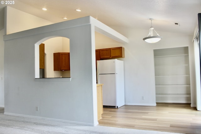 203 Robin Ct, Creswell, OR 97426 - kitchen with freestanding refrigerator, lofted ceiling, brown cabinetry, light wood-style flooring, and decorative light fixtures