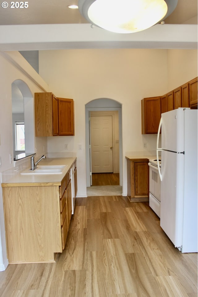 203 Robin Ct, Creswell, OR 97426 - kitchen with white appliances, a sink, arched walkways, and light wood finished floors