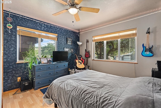 18122 Hulden Ln, Arlington, OR 97812 - bedroom with wallpapered walls, wood finished floors, a ceiling fan, and ornamental molding