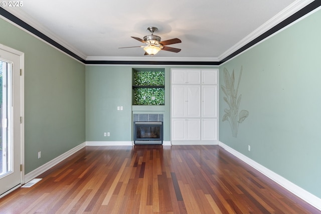 unfurnished living room featuring visible vents, ornamental molding, wood finished floors, a tile fireplace, and baseboards