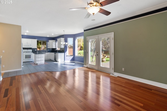 unfurnished living room with french doors, dark wood-type flooring, visible vents, and baseboards