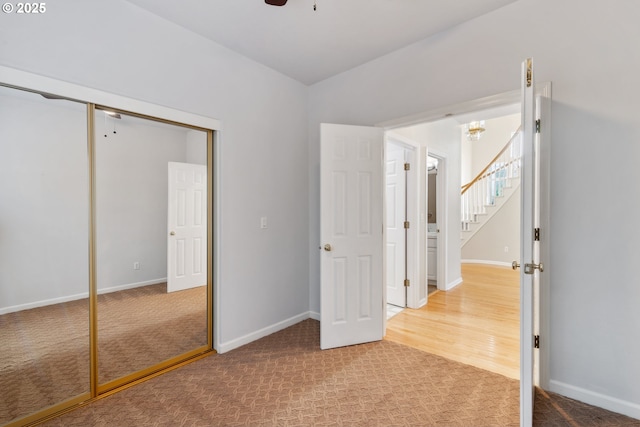 unfurnished bedroom featuring carpet floors, a closet, and baseboards