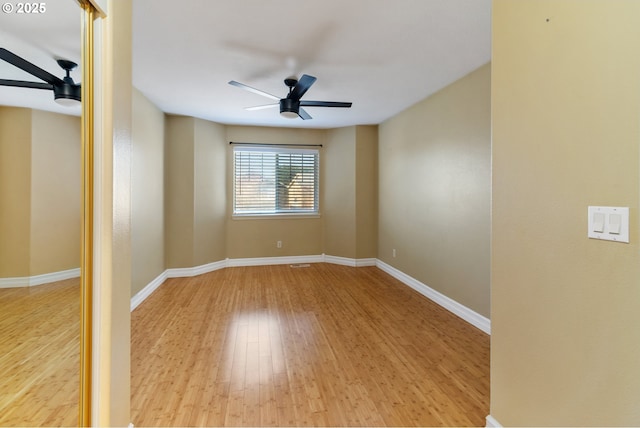 spare room featuring ceiling fan, baseboards, and wood finished floors